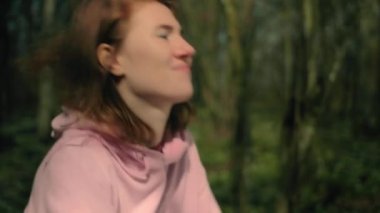 Yazar kız yaprağı fırlatıp atıyor ve ne yazık ki yaz ormanlarına bakıyor.