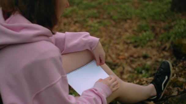 Penulis gadis duduk di hutan dengan lembaran putih kosong, berpikir tentang ide — Stok Video