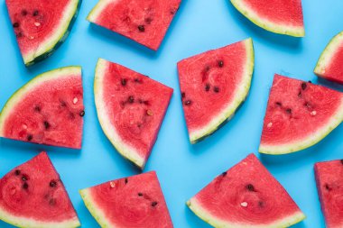 Mavi arka planda sulu karpuz dilimleri. Üst manzara, düz uzanma.