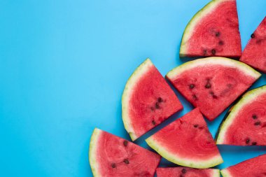 Mavi arka planda sulu karpuz dilimleri. Üst manzara, düz uzanma.