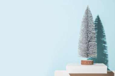 Mavi arka planda dekoratif Noel ağacı. Sert gölgeler.