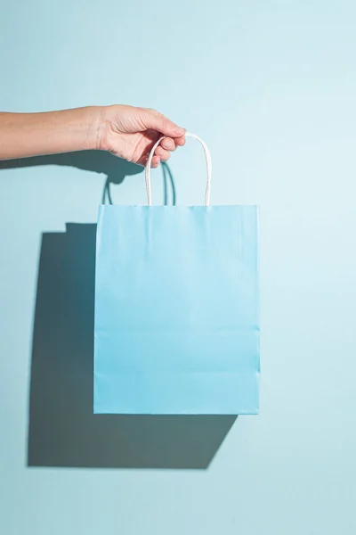 Mavi Arka Planda Kağıt Bir Alışveriş Çantası Tutuyor Sert Gölgeler — Stok fotoğraf