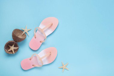 Terlikler, deniz yıldızları, mavi arka planda hindistan cevizi. Üst manzara, düz uzanma 