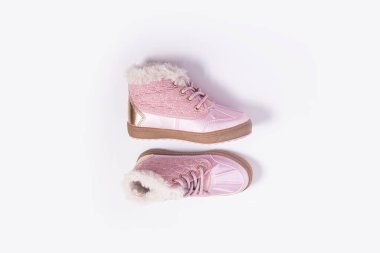 Beyaz arka planda pembe çocuk ayakkabıları. Üst manzara, düz uzanma