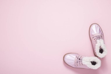 Pembe arka plandaki bir kız için çizmeler. Üst manzara, düz uzanma 