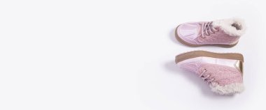Beyaz arka planda pembe çocuk ayakkabıları. Üst manzara, düz yatış. Pankart