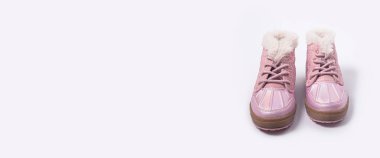 Beyaz arka plandaki bir kız için modaya uygun çocuk botları. Pankart