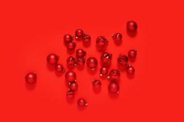 Kırmızı arka planda beyaz kare kaidede kırmızı dekoratif toplar.