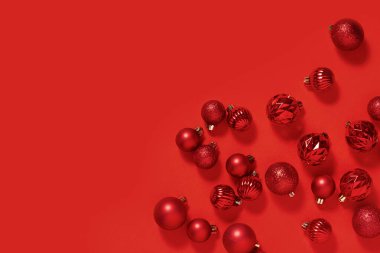 Kırmızı arka planda beyaz kare kaidede kırmızı dekoratif toplar.