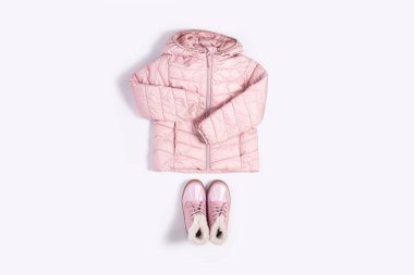 Beyaz arka plandaki bir kız için çocuk ceketi ve botları. Üst manzara, düz uzanma.
