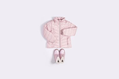 Beyaz arka plandaki bir kız için çocuk ceketi ve botları. Üst manzara, düz yatış. Pankart.