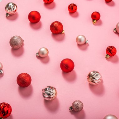 Pembe arka planda kırmızı ve pembe dekoratif toplar. Üst manzara, düz uzanma