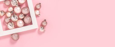Kare beyaz podyum ve pembe arka planda pembe dekoratif toplar. Üst manzara, düz yatış. Pankart