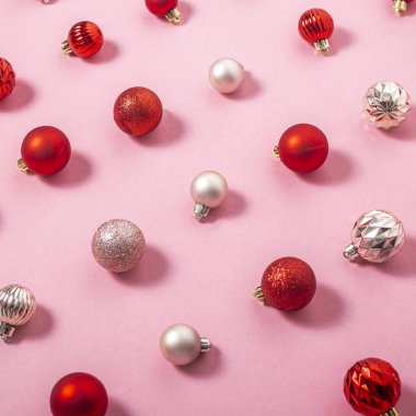 Pembe arka planda pembe ve kırmızı dekoratif toplar. Üst manzara, düz uzanma