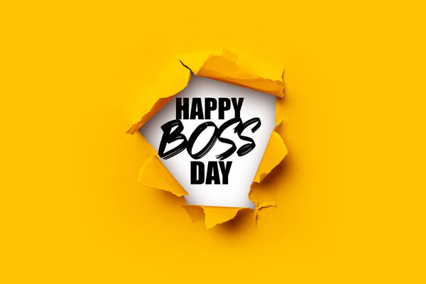 Bright yellow torn paper inside in a hole the inscription Happy boss day on a white background