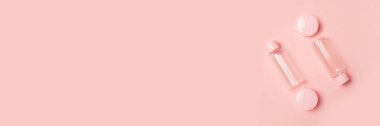 Pastel pembe arka planda kozmetik için boş tüpler. Düz yerde, üst tarafta. Pankart.