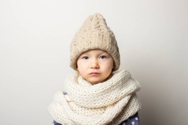 Hafif arka planda şapkalı güzel bir bebek. Çocuk duyguları kavramı, kış, alışveriş.