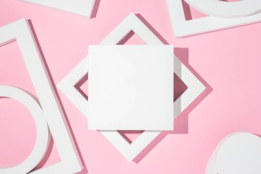 Beyaz sunum, pembe arka planda geometrik şekiller sunar. Üst manzara, düz uzanma.