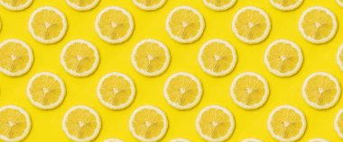 Sarı arka planda olgun limon dilimlerinin olduğu bir arka plan. Üst manzara, düz yatış. Pankart.