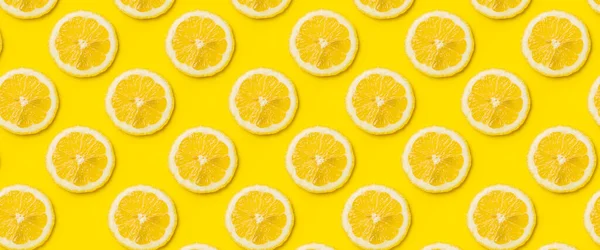 Sarı arka planda olgun limon dilimlerinin olduğu bir arka plan. Üst manzara, düz yatış. Pankart.