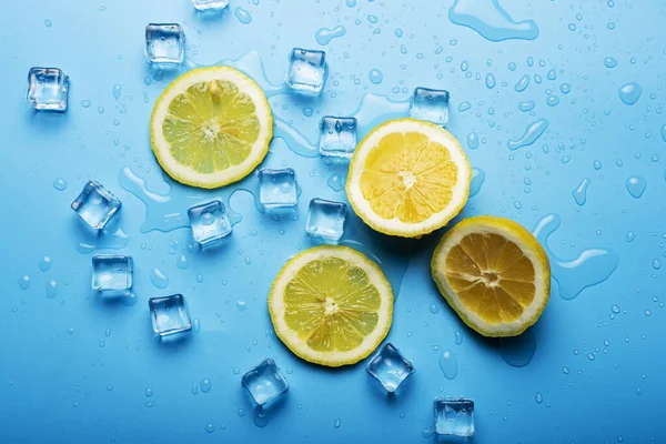 Saftige Frische Gelb Geschnittene Zitronen Und Eiswürfel Auf Blauem Hintergrund — Stockfoto