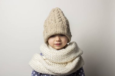 Hafif arka planda şapkalı güzel bir bebek. Çocuk duyguları kavramı, kış, alışveriş.