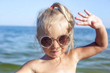 Yaz günü plajda güneş gözlüklü güzel bir kız. 