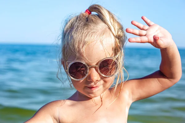 Yaz günü plajda güneş gözlüklü güzel bir kız. 