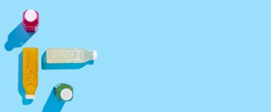 Mavi arka planda plastik şişelerde renkli detoks içeceği. Üst manzara, düz yatış. Pankart 