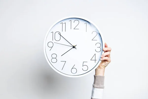 Mano Mujer Sostiene Gran Reloj Blanco Sobre Fondo Claro — Foto de Stock