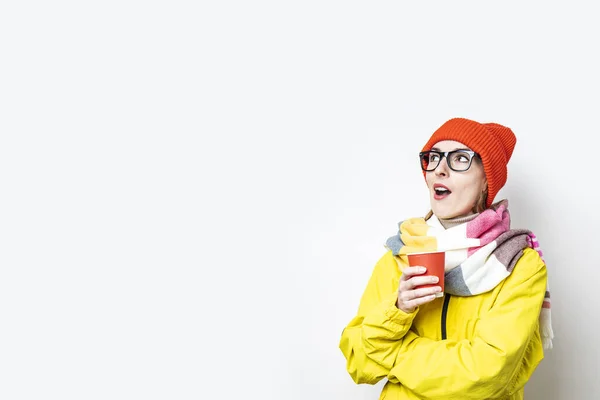 Mujer Joven Con Una Taza Papel Mira Sorprendida Sobre Fondo — Foto de Stock