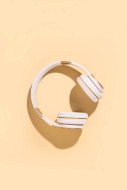 Bej arka planda kablosuz kulaklık. Düz yatış, üst görünüm