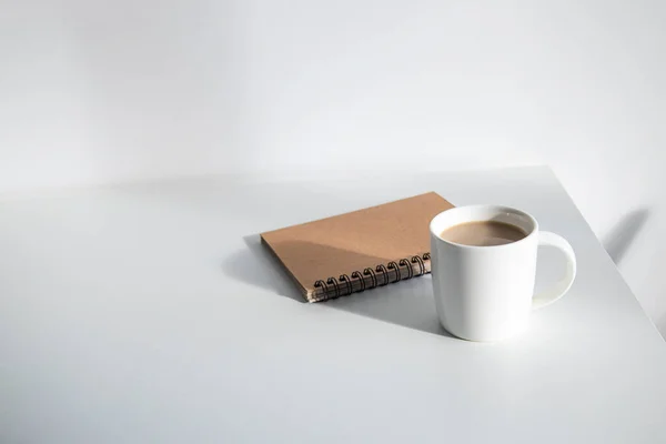 Weiße Tasse Mit Kaffee Notizbuch Auf Weißem Tisch Unter Tageslicht — Stockfoto