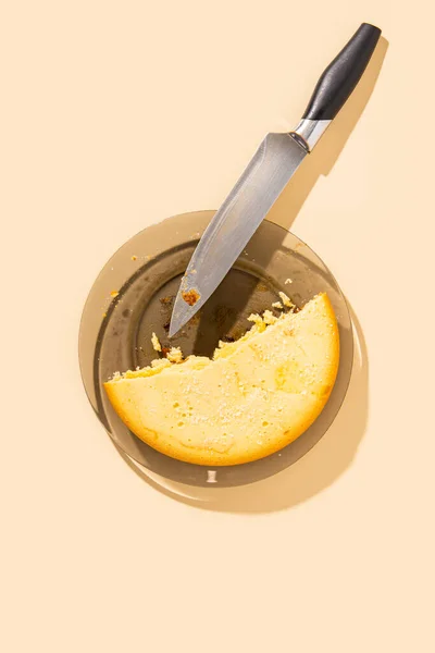 皿の上のパイの半分 ベージュの背景のナイフ トップビュー フラットレイアウト — ストック写真