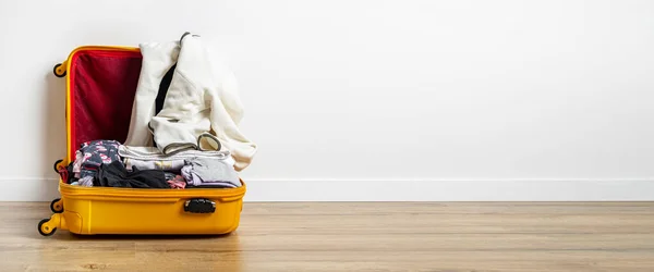 Offener Gelber Koffer Mit Kleidung Auf Einem Holzboden Vor Einer — Stockfoto