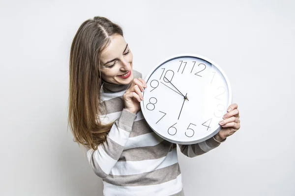 Mujer Joven Sonriente Mirando Reloj Pared Blanco Sobre Fondo Claro — Foto de Stock