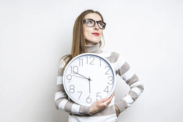 Mujer Joven Pensativa Mirando Hacia Arriba Sosteniendo Reloj Sobre Fondo — Foto de Stock