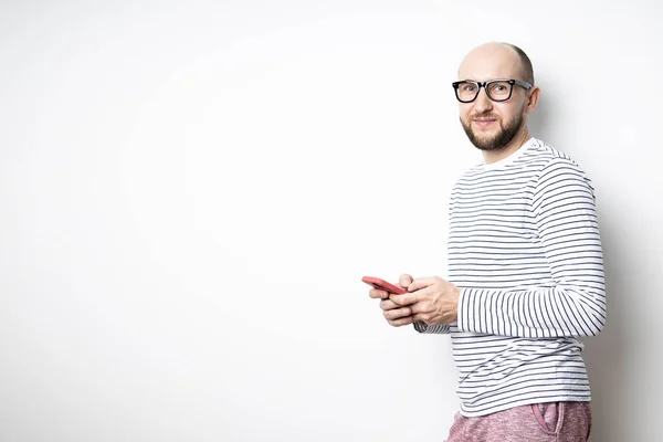 Barbudo Con Gafas Sostiene Teléfono Sus Manos Apoya Contra Una — Foto de Stock