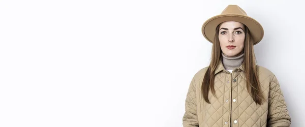 白い壁の背景に帽子をかぶったジャケットの美しい若い女性 バナー — ストック写真