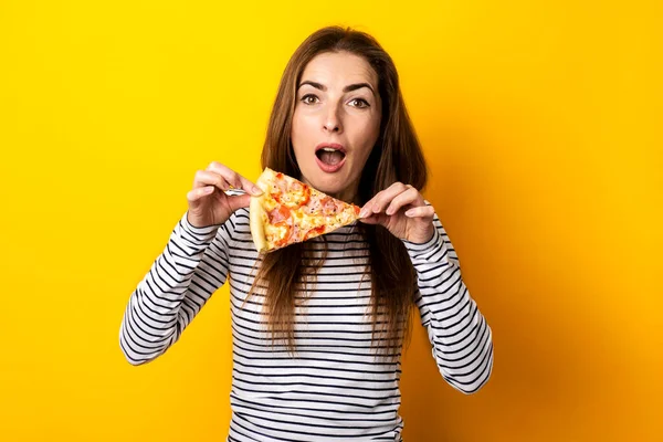Удивленный Молодой Женщины Выглядит Держа Кусок Горячей Свежей Пиццы Желтом — стоковое фото