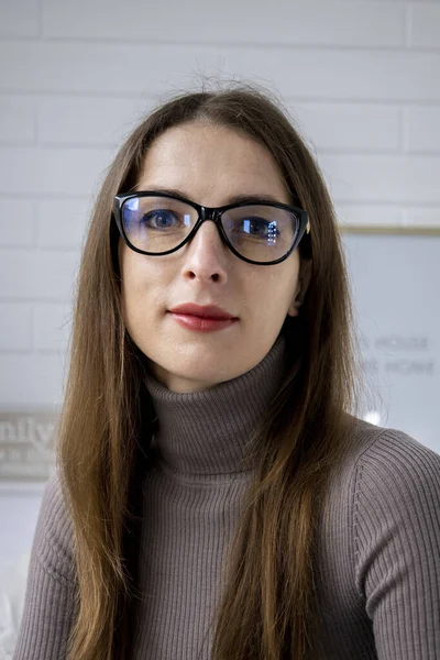 Golshki 'de beyaz bir duvarın arkasındaki odada gözlüklü güzel bir genç kadın..