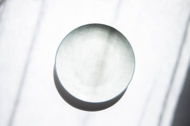 Doğal ışık altında beyaz arka planda boş bir plaka. Üst manzara, düz uzanma.