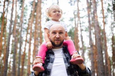 Babasıyla bir çocuk ormanda yürüyüş yaparken. Aile dağlara ya da ormana gider..