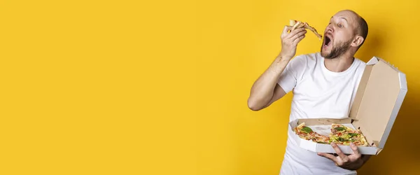 Young Man Eating Hot Fresh Pizza Packaging Yellow Background Banner — Stock Photo, Image