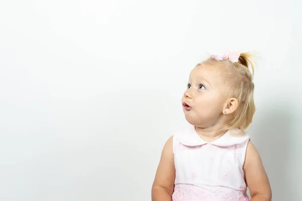 Little girl with a surprised face on a light background. Banner. Concept little model, princess, surprise.