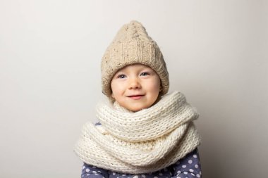 Hafif arka planda şapkalı güzel bir bebek. Çocuk duyguları kavramı, kış, alışveriş.