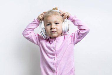 Kulaklıklı çocuk hafif bir arka planda müzik dinliyor.