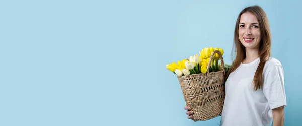 Mujer Joven Sonriente Sosteniendo Tulipanes Amarillos Canasta Sobre Fondo Azul — Foto de Stock