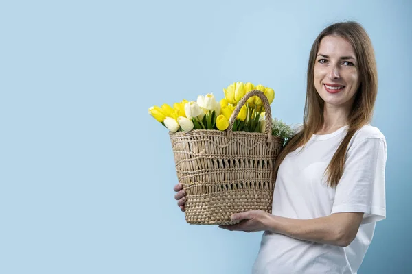 Mujer Joven Sonriente Sosteniendo Tulipanes Amarillos Canasta Sobre Fondo Azul — Foto de Stock