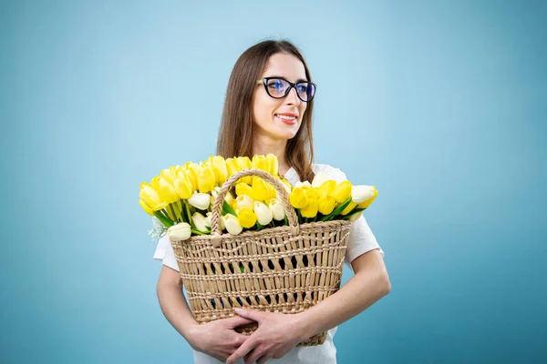 Mujer Joven Sonriente Sosteniendo Tulipanes Amarillos Canasta Sobre Fondo Azul — Foto de Stock